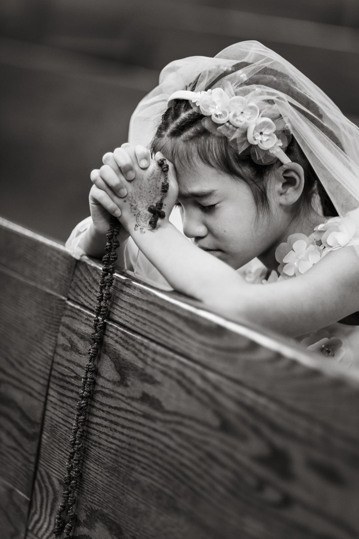 girl praying in pew